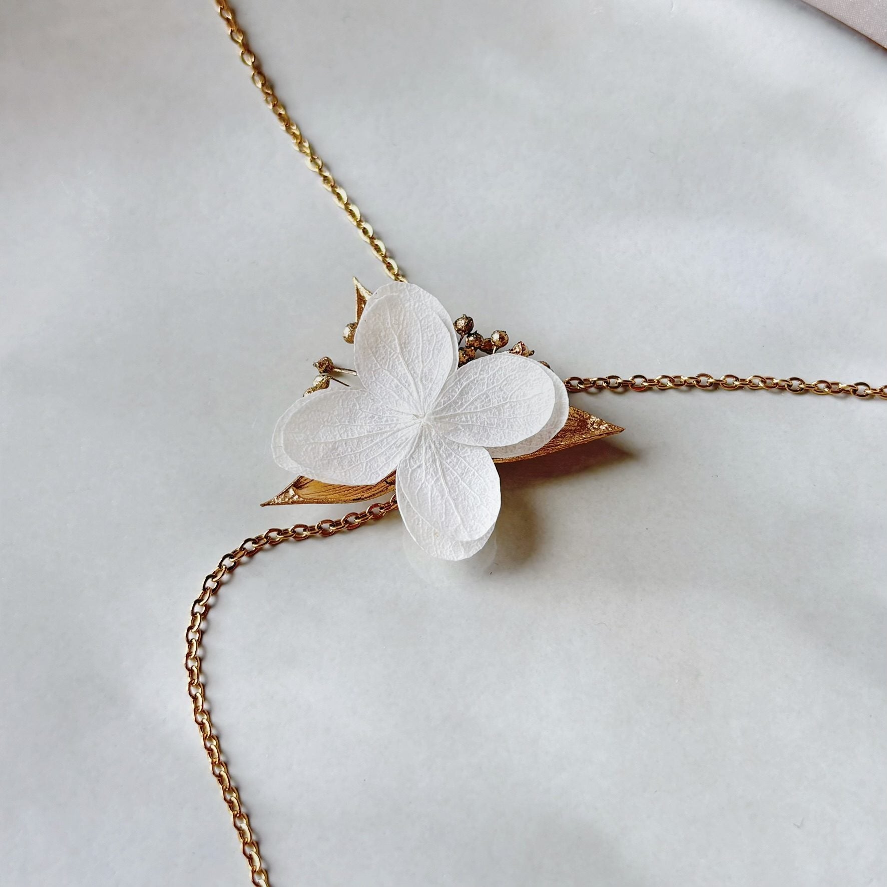 Collier mariage perlé avec hortensias stabilisés et finitions dorées