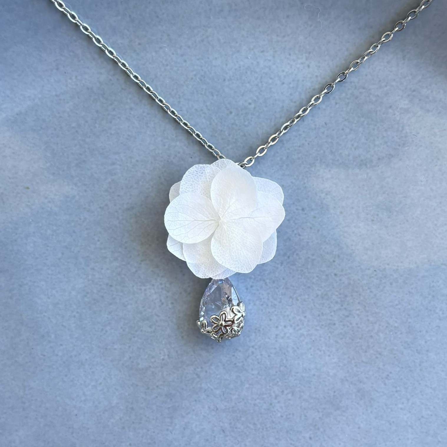 Accessoire de mariage élégant Hana&Alice : collier orné de fleurs stabilisées et d’un cristal scintillant pour un look inoubliable.