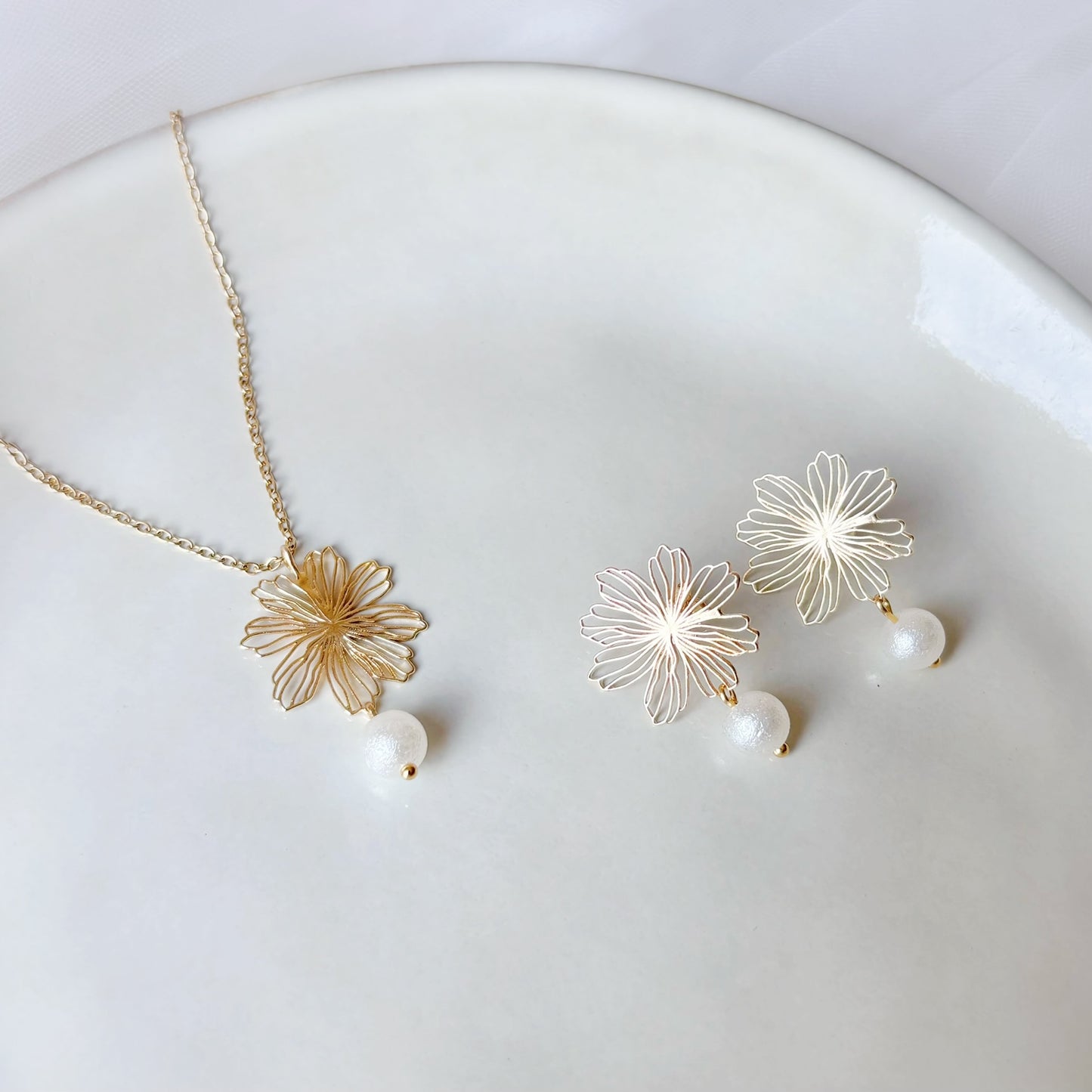 Collier et boucles d’oreilles de mariée assortis avec fleur dorée délicate et perle ronde texturée