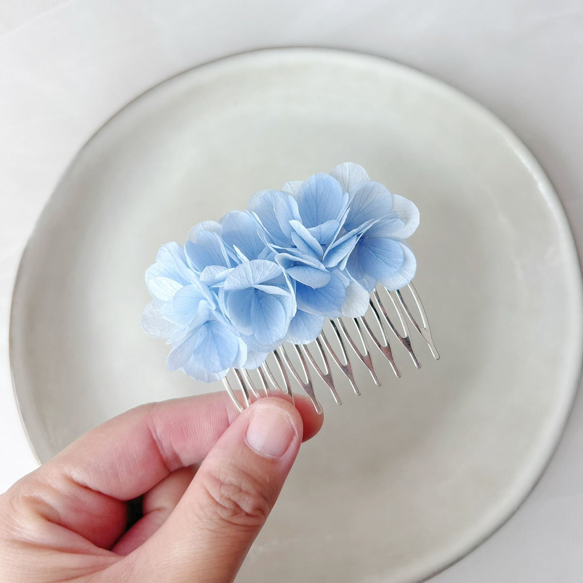 Peigne floral bleu clair pour mariée lors d’un mariage bohème chic