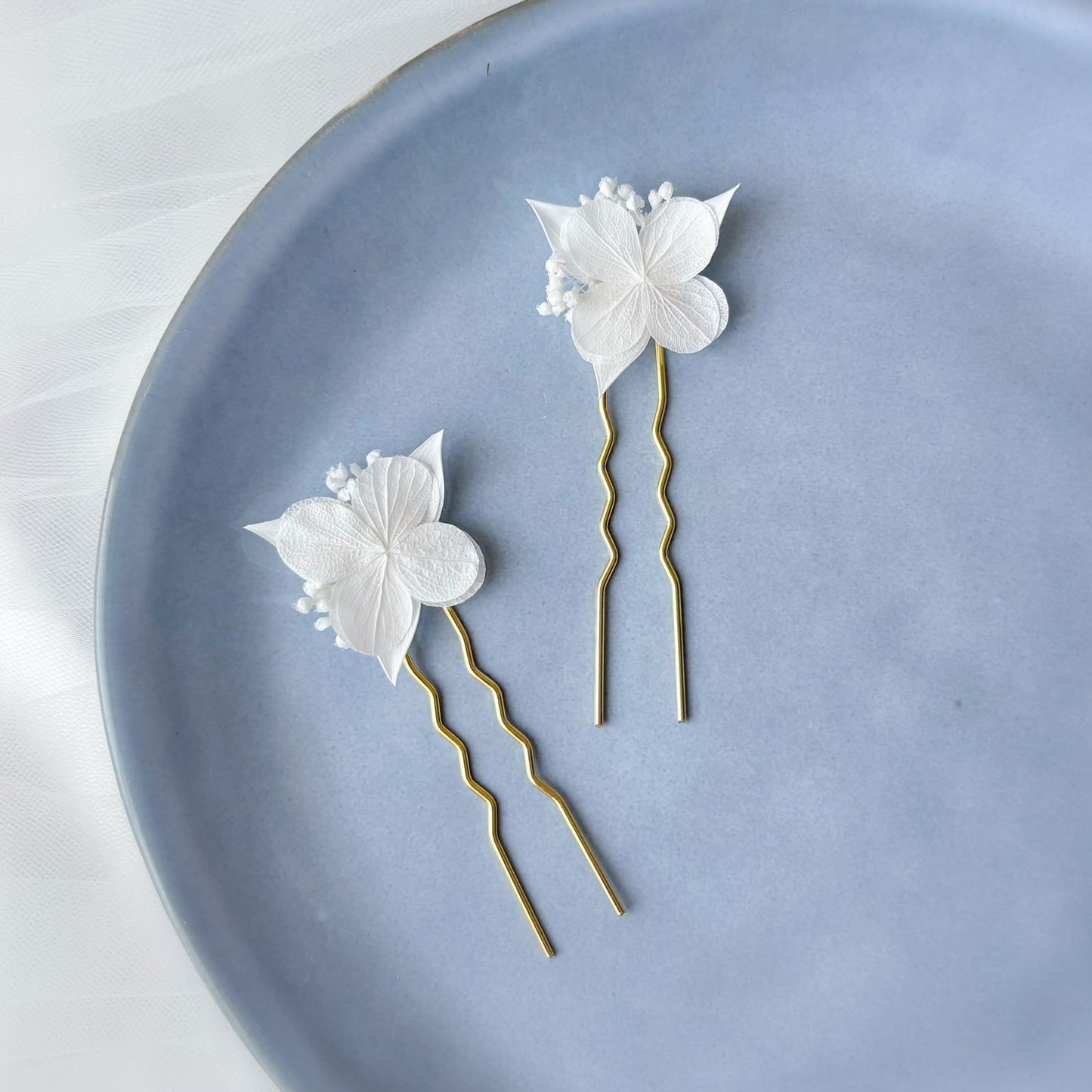 Piques à cheveux pour mariée réalisées à la main avec délicats hortensias stabilisés blancs et feuillage naturel